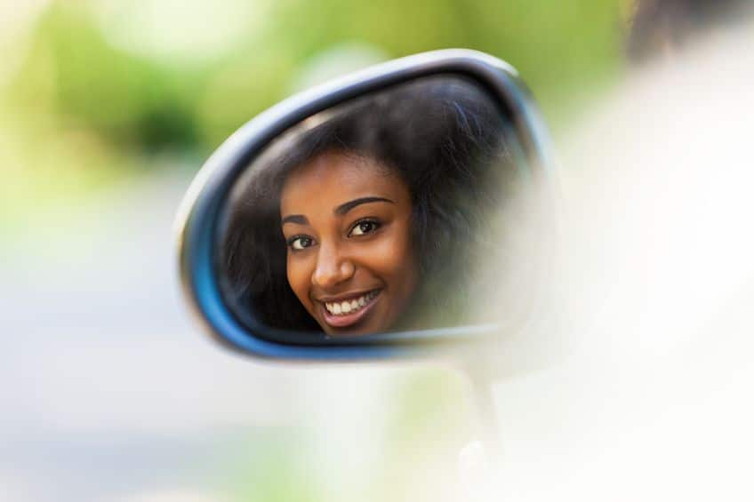 Woman looking at you in reave view mirror