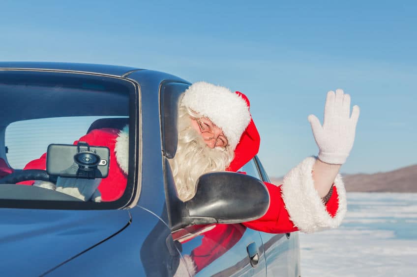 Santa waving out of the driver side window of car